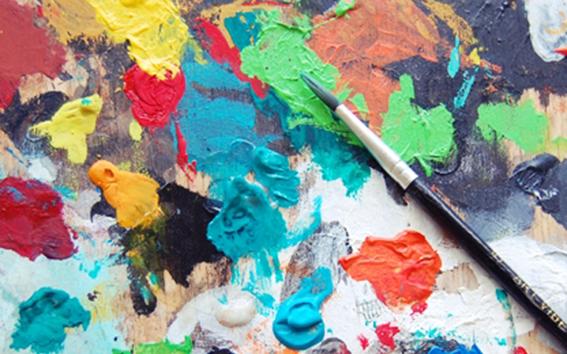 Paint brush on a colorful canvas.